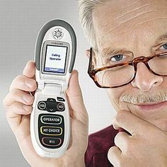 a man with glasses holding up an old cell phone