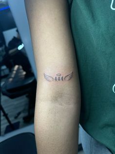 a man with a tattoo on his arm that reads angel and has an arrow in the middle