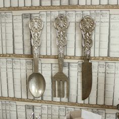 there are spoons, spatulas and other kitchen utensils hanging on the wall