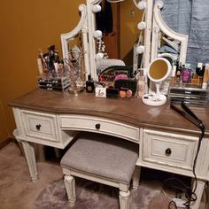 a vanity with stool and mirror in a room