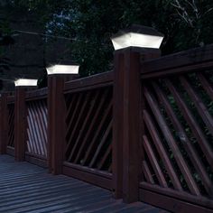 three lights that are on top of a wooden fence