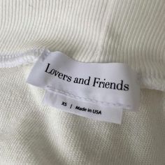 a label that says lovers and friends on the side of a white shirt with black lettering