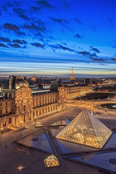 an aerial view of the pyramids and buildings in paris, france at night time