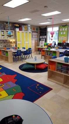 a classroom filled with lots of desks and colorful rugs on top of the floor