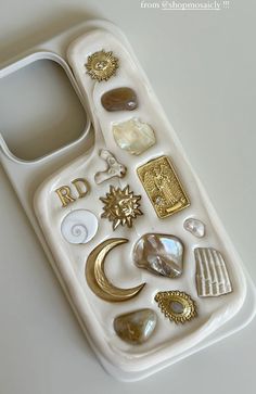 a white cell phone with lots of different items on it's back cover,