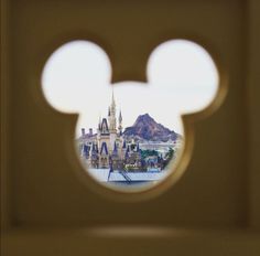 the reflection of a castle through a hole in a wall with a mouse head on it