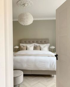 a white bed sitting next to a doorway in a bedroom