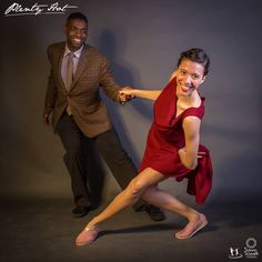 a woman in a red dress is dancing with a man