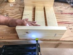 a person is working on some wood with a small piece of glue in their hand