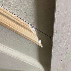 a piece of wood that has been taped to the side of a wall with nails on it