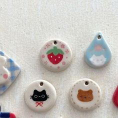 four different shaped buttons with animals on them and one has a strawberry, cat, dog, and bear design