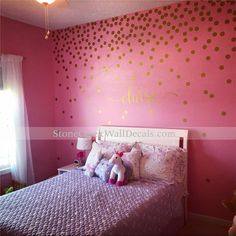 a bedroom decorated in pink and gold with polka dots on the wall