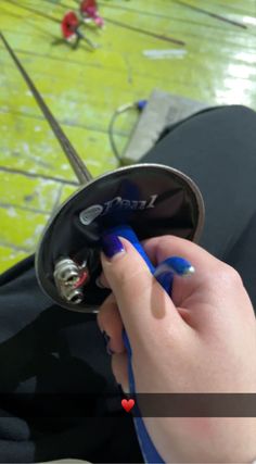 a person with blue nails is holding a black object