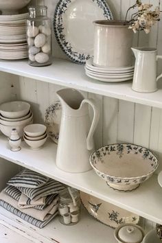 the shelves are filled with dishes and vases