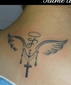 a woman with a cross and wings tattoo on her back