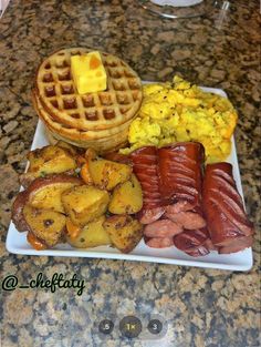 a white plate topped with waffles, potatoes and bacon