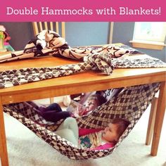 a baby sitting in a hammock under a table