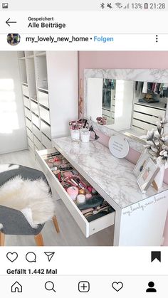 a white vanity with lots of drawers and mirrors on it's sides in a pink room