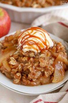 an apple crisp with ice cream and caramel drizzle is on a white plate