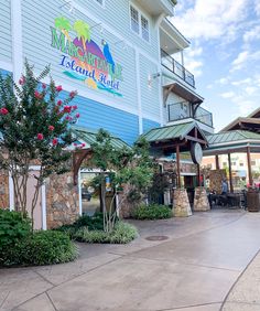 the front entrance to margarita island resort with people sitting at tables and umbrellas over looking the ocean