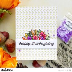 an image of a happy thanksgiving card surrounded by flowers and crafting supplies on a table