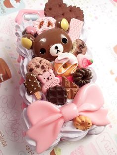 a teddy bear is sitting on top of a pile of cookies and candies with a pink bow