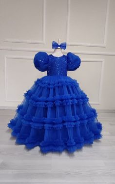 Celebrate in style with our Royal Blue Flower Girl Ball Gown! This exquisite dress is perfect for any special occasion, whether it's a wedding, birthday party, or princess-themed event. Made with attention to detail and a touch of magic, this baby blue princess dress will make your little one feel like royalty. The special design features a puffy tutu skirt that adds volume and flair, creating a truly enchanting look. Crafted with care and made for comfort, this dress is sure to be a hit with both parents and princesses alike. Order now and let your little one shine bright like a star. Kids Ball Gowns Princesses, Blue Ruffled Dress For Wedding, Blue Princess Style Party Dress, Blue Tulle Dress For Party, Fitted Blue Tutu Dress For Pageant, Light Blue Ball Gown Princess Dress For Parties, Fitted Blue Pageant Dress For Dress-up, Blue Tulle Party Dress, Light Blue Ruffled Party Gown