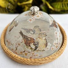 a basket with birds painted on it sitting on a table