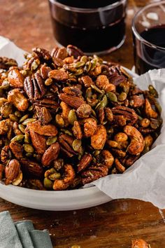 a white bowl filled with nuts on top of a wooden table