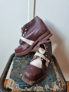 RARE, article de collection  Improbable paire de bottines de montagne des années 1940. Elles proviennent d'un stock français d'époque, et n'ont jamais été portées.  Il est si rare de trouver de telles pièces de nos jours ! Bottines bicolores en cuir marron foncé et crème. Brides sur le cou-de-pied, crochets et oeillets en alu pour passage du lacet. Semelles bois. Boucles en métal sur les brides.   Merci d'examiner attentivement les photos, qui font partie intégrante de la description.. Article p Vintage High-top Boots, Vintage Closed Toe Boots With Rubber Heel Cap, Vintage Brown Boots With Rubber Heel Cap, Vintage Boots With Leather Footbed And Moc Toe, Vintage Leather Shoes With Moc Toe And Stitched Sole, Vintage High-top Boots With Rubber Sole, Brown Brogue-detailed Plain Toe Moccasins, Brown Military Boots, Military Leather Boots With Reinforced Toe