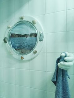 there is a blue towel hanging on the wall next to a mirror with seashells in it