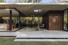 a modern house with glass walls and wooden doors