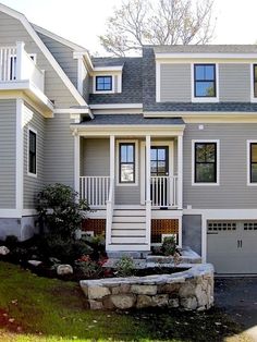 a large gray house with white trim and windows