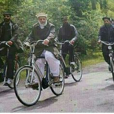 a group of men riding bikes down a road