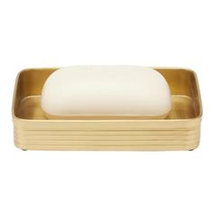 the soap dish is gold and has a white bar on it, sitting in front of a white background