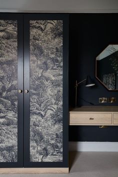 a black and white wallpapered closet in a room with a mirror on the door