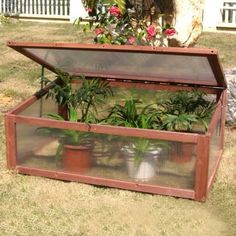 a wooden box filled with plants on top of grass