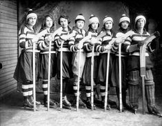 a group of women standing next to each other holding hockey sticks