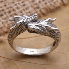 Mythical and mysterious Budiharta's silver ring features two dragons wrapped up in romance. The Balinese artisan hand crafts the wrap-style ring from sterling silver engraving the precious metal with a raised pattern that resembles dragon scales. Medieval Engraved Jewelry For Anniversary, Adjustable Sterling Silver Dragon Jewelry, Adjustable Sterling Silver Jewelry With Dragon Design, Silver Adjustable Engraved Snake Ring, Adjustable Carved Silver Ring, Unique Adjustable Dragon Design Jewelry, Adjustable Unique Jewelry With Dragon Design, Unique Sterling Silver Ring With Dragon Design, Adjustable Engraved Snake Ring Gift