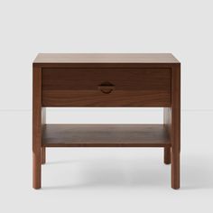 the side table is made from wood and has an open drawer on one end,