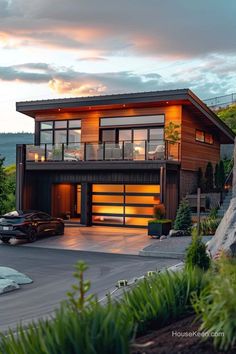 a modern house is shown at dusk with the sun setting in the background and cars parked on the driveway