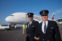 two pilots standing in front of an airplane