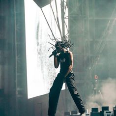 a man standing on top of a stage holding a microphone