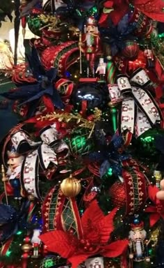 a christmas tree decorated with red, green and blue ribbons