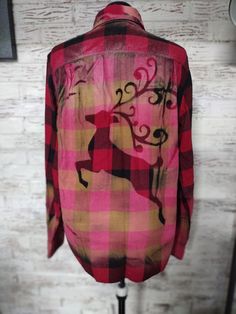 a pink and black plaid shirt with a deer on it