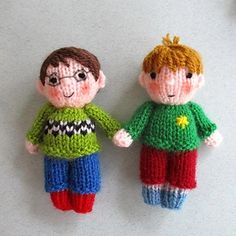 two knitted dolls holding hands on a table