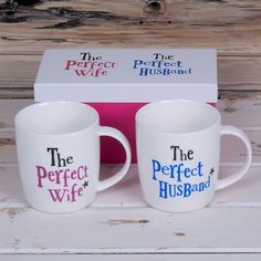 two coffee mugs with the perfect wife and the perfect husband printed on them in front of a box