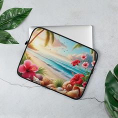 a laptop case with flowers and seashells painted on the cover, next to a potted plant