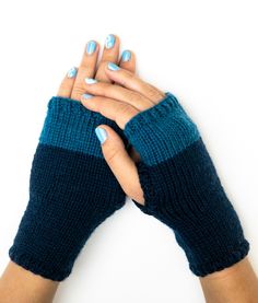 a woman's hands with blue and white manicures holding her fingers together