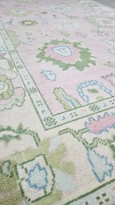 a pink rug with green and blue designs on the top is laying on its side